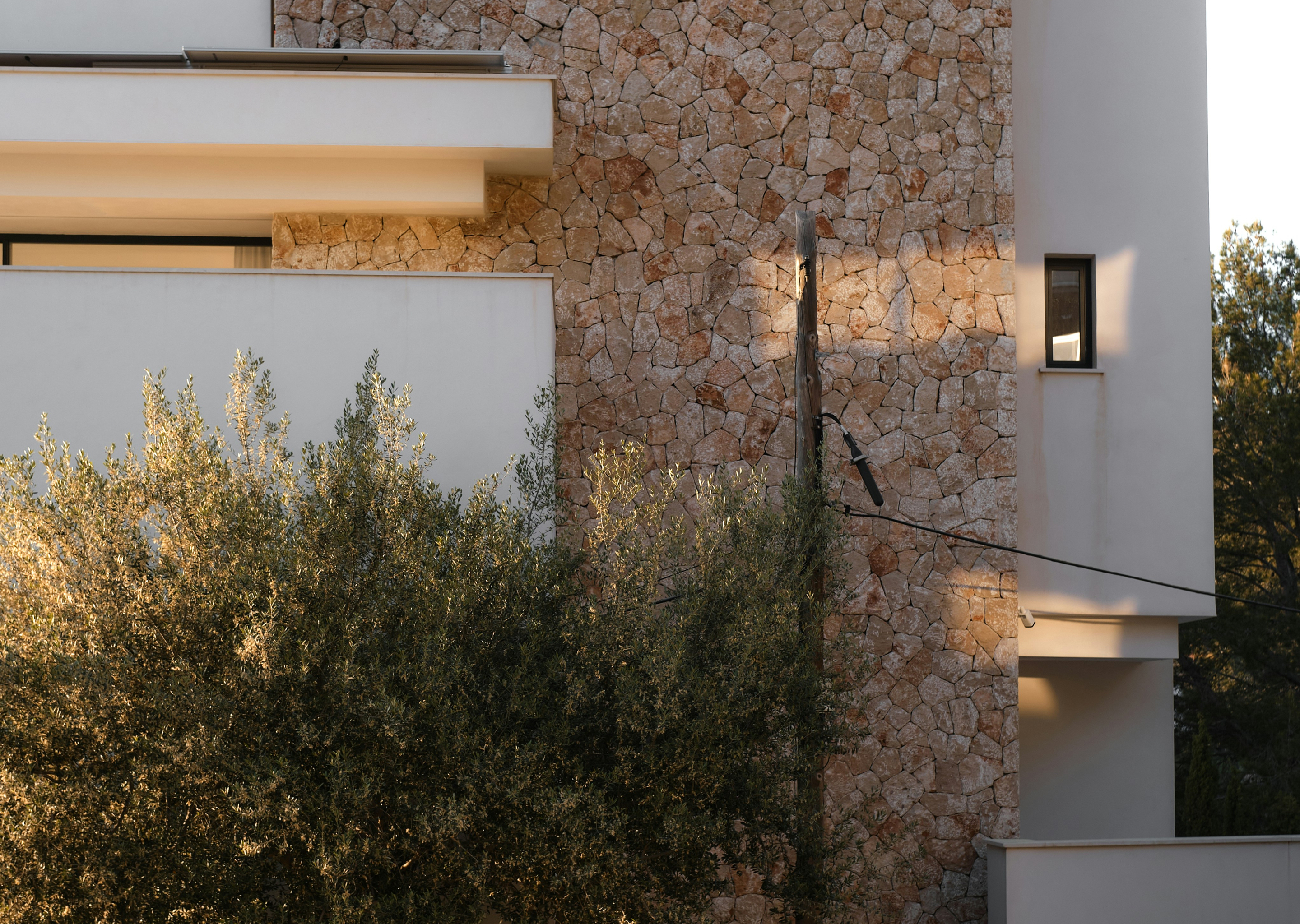 Arquitectura moderna con piedra natural y vegetación mediterránea